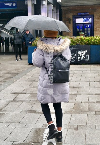 People out in the heavy rain at Reading Station