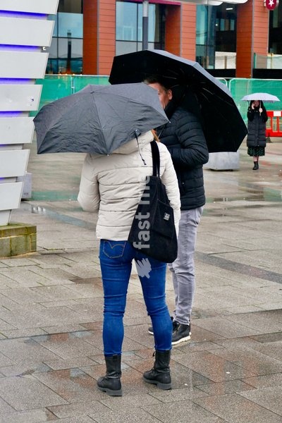 People out in the heavy rain at Reading Station