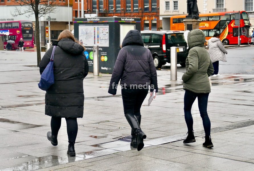 People out in the heavy rain at Reading Station