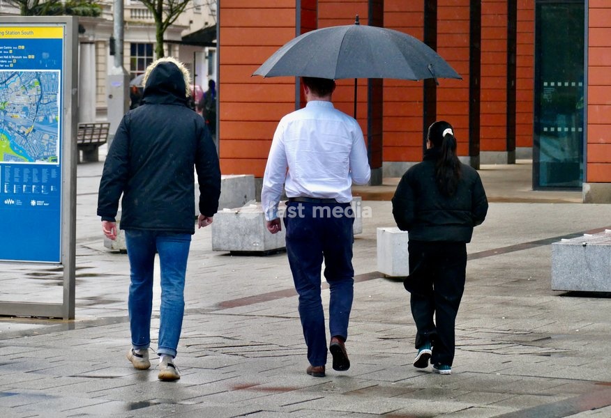 People out in the heavy rain at Reading Station