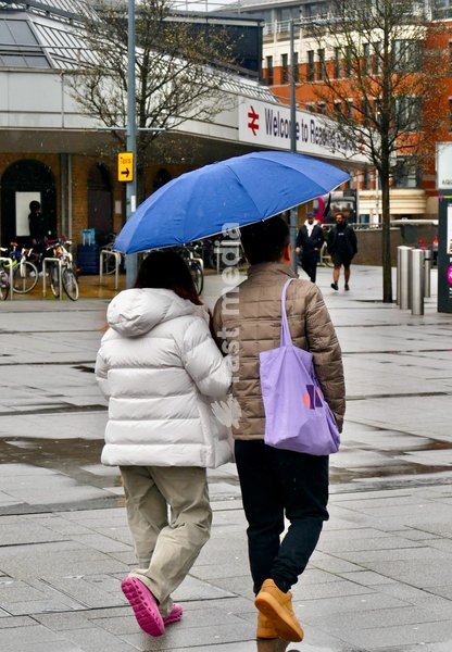 People out in the heavy rain at Reading Station