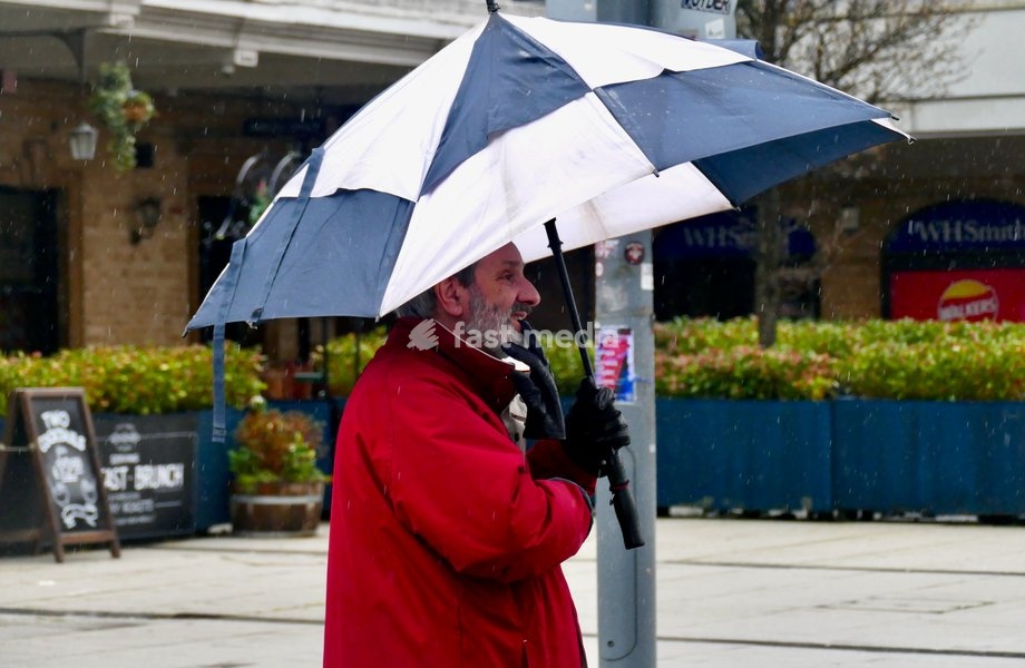 People out in the heavy rain at Reading Station