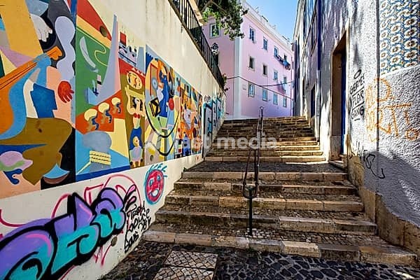 A colorful street art mural lines a staircase in an urban alleyway, adding vibrancy to the city, Alfama, Lisbon