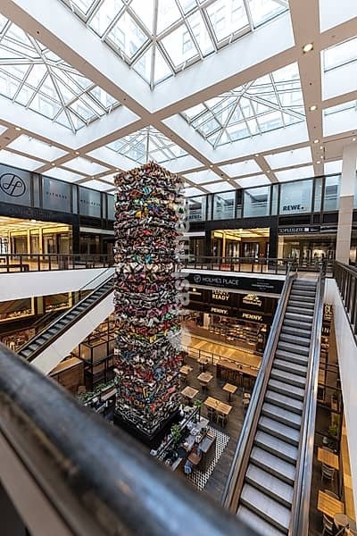 Multi-storey shopping centre with escalators and a central art installation, Berlin, Germany, Europe