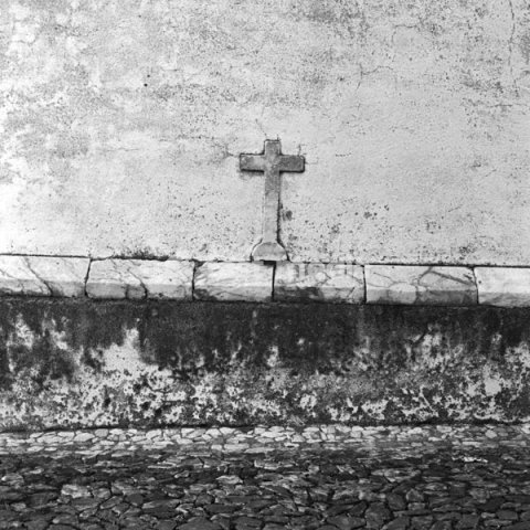 Stone cross incorporated in the wall of a house Portugal, Europe