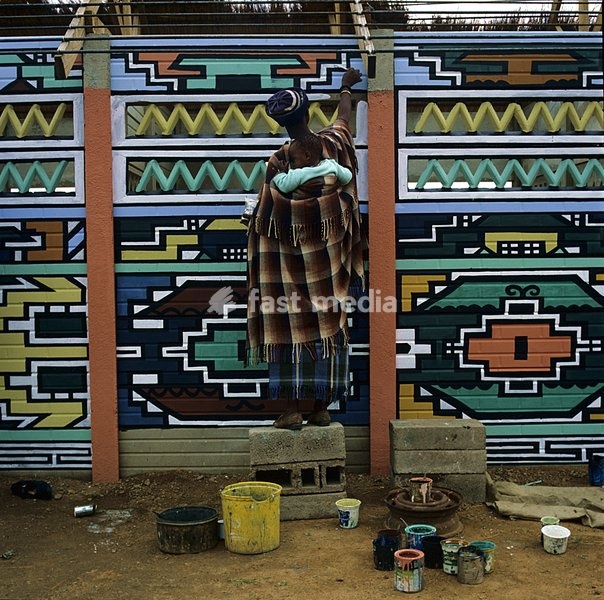 Letty Ngoma painting the prefabricated market stalls in Waterval B, KwaNdebele. These stalls were built under the supervision of the KwaNdebele government as part of its program to encourage traditional mural painting