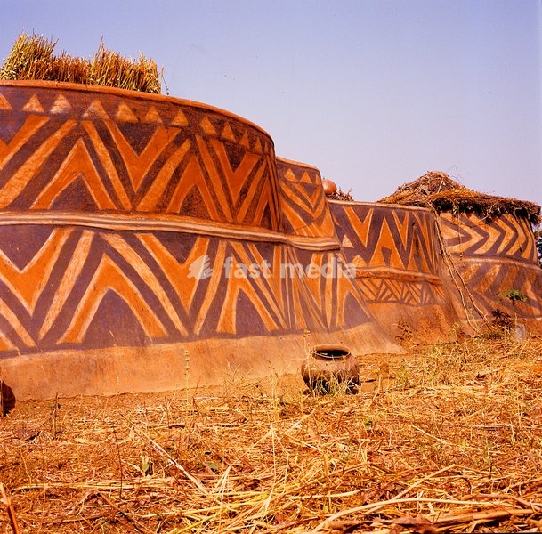 Solid and fortress-like, this back view of the Aneriba family compound is decorated with bold V-shaped patterns, a somewhat simplified version of the tana motif derived from local fabrics. The walls are coated with resin from the dawa-dawa tree to protect the surface from the rains. Sirigu, Ghana