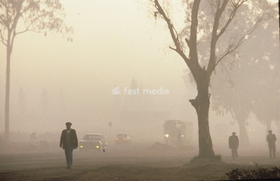 Pedestrians and vehicles on a misty morning in Soweto