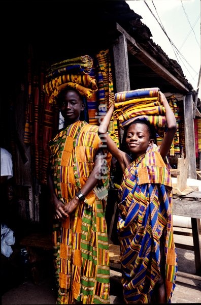 Ghanaian children carrying Kente cloth at a market in Bonwire-Ashanti