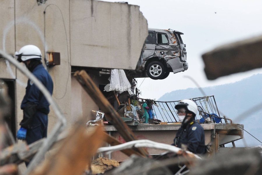 IWATE (JAPAN), March 22, 2011 () -- Rescuers work in quake-devastated Iwate Prefecture, Japan, on March 21, 2011. The tsunami disaster has actually inundated a large area behind the board. The National Police Agency said Tuesday that the catastrophic earthquake and ensuing tsunami have left 9,079…