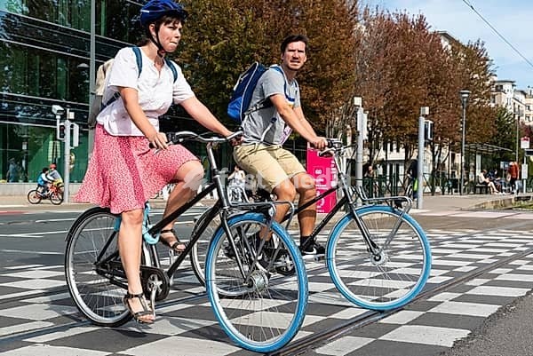 Etterbeek, Brussels Capital Region, Belgium, 09 20 2020 Young couple in summer clothes driving a bike at the car free sunday, Europe
