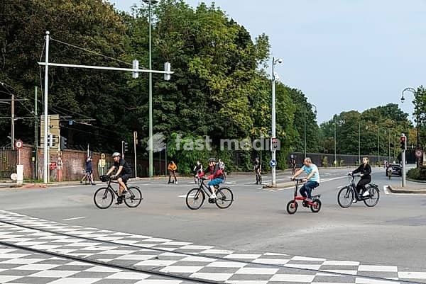 Laeken, Brussels Capital Region, Belgium, Brussels, 09 24 2021: People of all ages driving the bike at a bussy cross during car free sunday, Europe