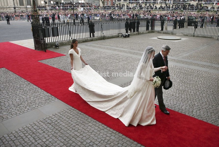 Kate Middleton, center, accompanied by her father Michael Middleton, right, and her sister Pippa Middleton, who is the maid of honour, enter Westminster Abbey ahead of her marriage to Britain's Prince William, London, Friday, April 29, 2011
