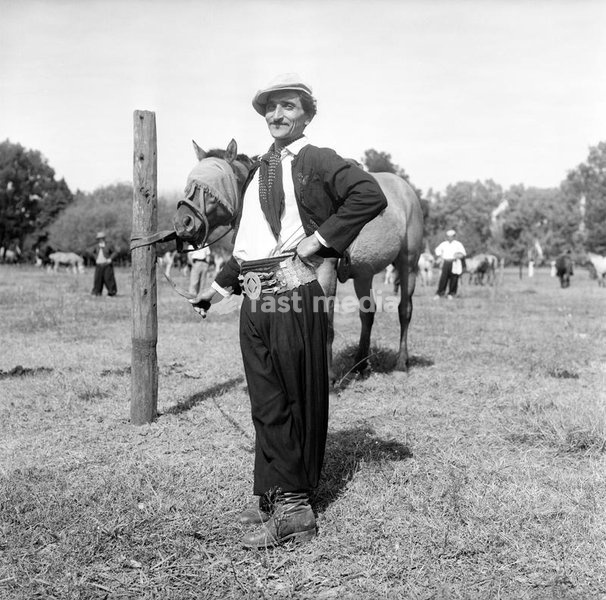 A gaucho poses beside his horse, gauchos are the typical South American cattlemen, the equivalent of North American cowboys, found in the pampas in parts of Argentina, Uruguay, Paraguay and Southern Brazil; they are good horsemen and use bolas to hunt. Argentina, april 1961. SPECIAL FEE - CONTACT…