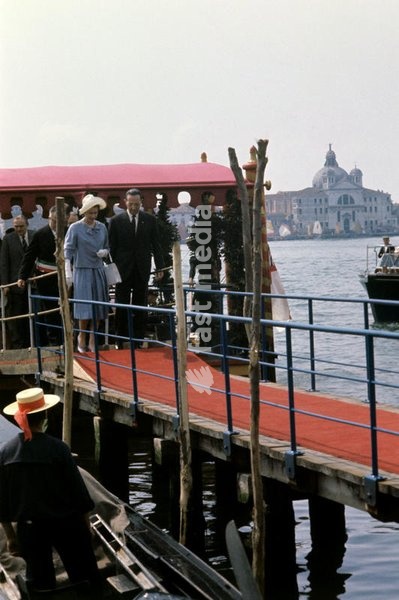 Queen Elizabeth II, visiting Venice for the first time, in the occasion of the celebrations for the national unification's centenary, crosses the red footbridge, followed by the Mayor Giovanni Favaretto Fisca. Venice (Italy), May 1961. SPECIAL FEE - CONTACT US FOR NOT EDITORIAL USAGE
