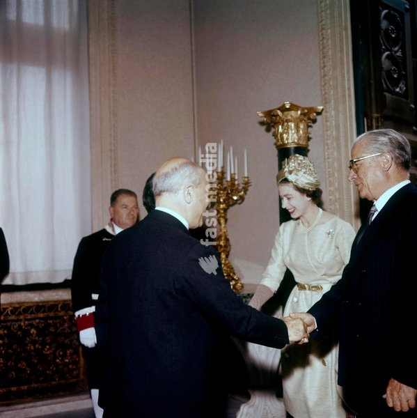 The Queen Elizabeth of the United Kingdom, during her official visit in Italy for the centenary of the Unification, meets the President of the Republic Giovanni Gronchi and the italian Premier Amintore Fanfani; Gronchi, on the right, is shaking hands with Fanfani, seen from behind. Rome (Italy),…