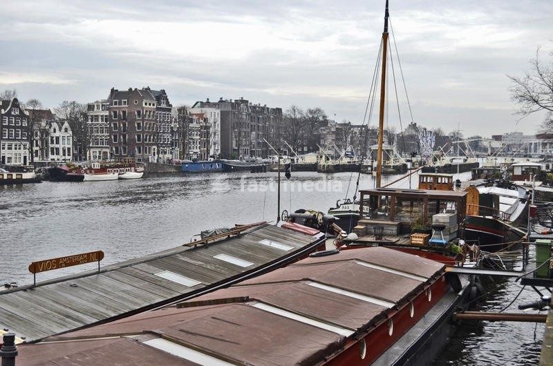 Canals in the old town center, with boats and floating houses on both sides. Amsterdam, 7th December 2016