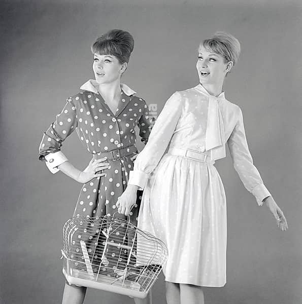 In the 1960s. Two fashion models, in typical 1960s summer dresses photographed in a studio. The two dresses are similar in patterns but are in different colors. Sweden 1960s